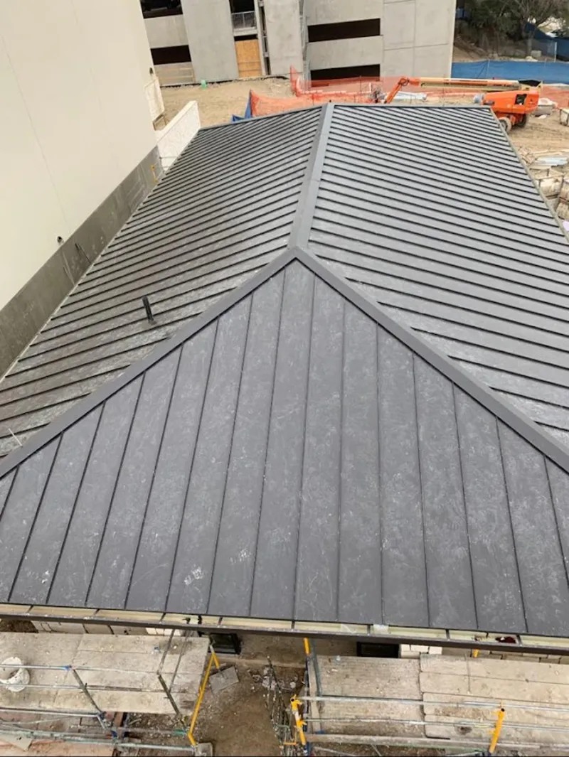 Commercial metal roof construction with crane equipment in Milwaukie